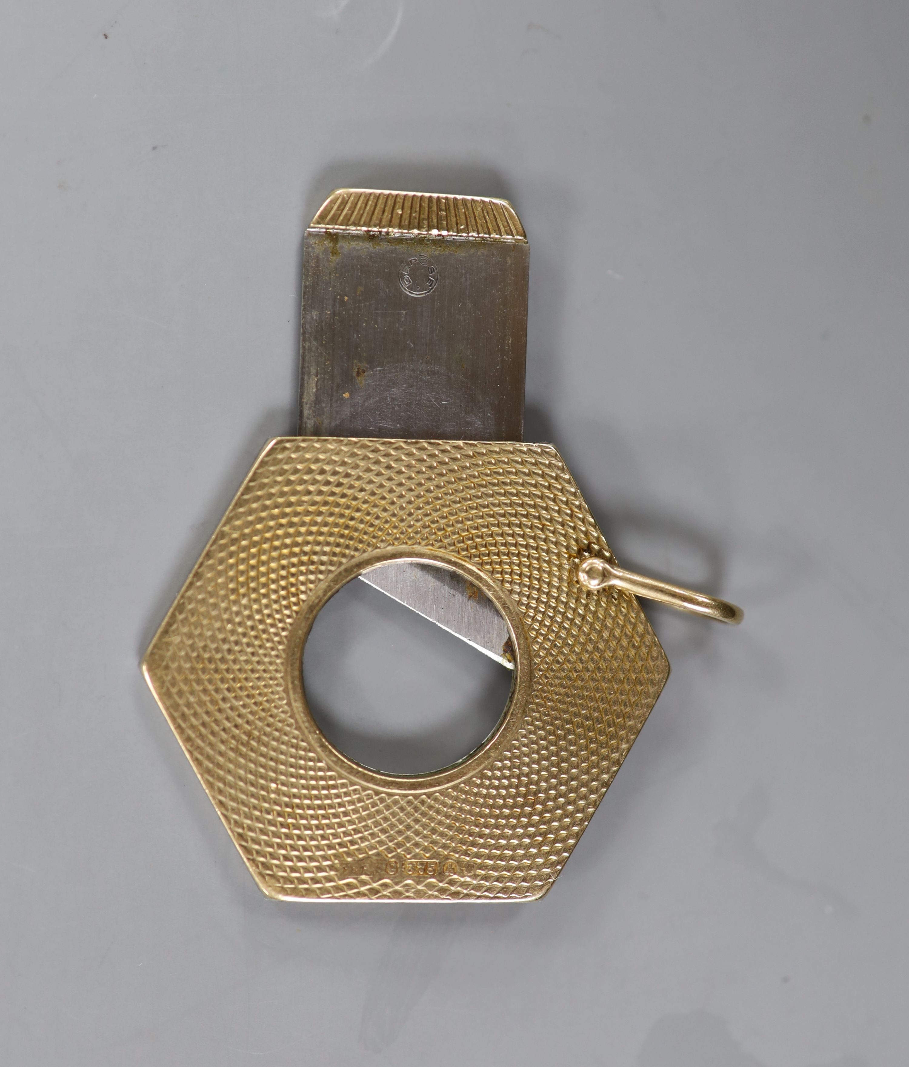 A 1960's engine turned 9ct gold hexagonal cigar cutter, 34mm.